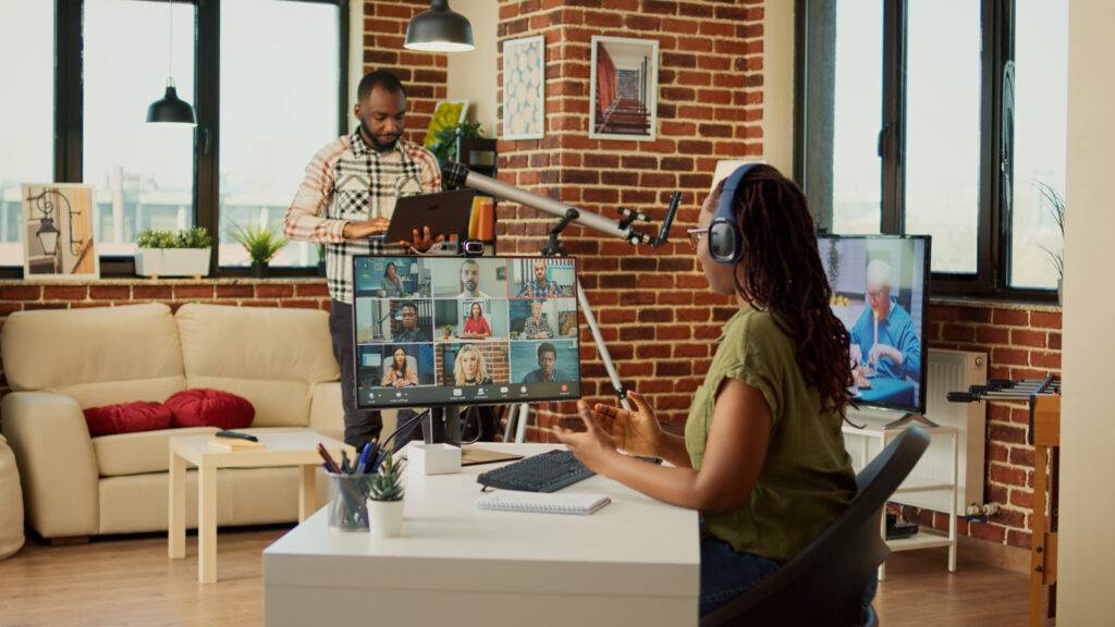 Office worker attending company meeting on videocall with webcam, using computer to talk to people on online teleconference. Young adult chatting on videoconference, remote work from home.